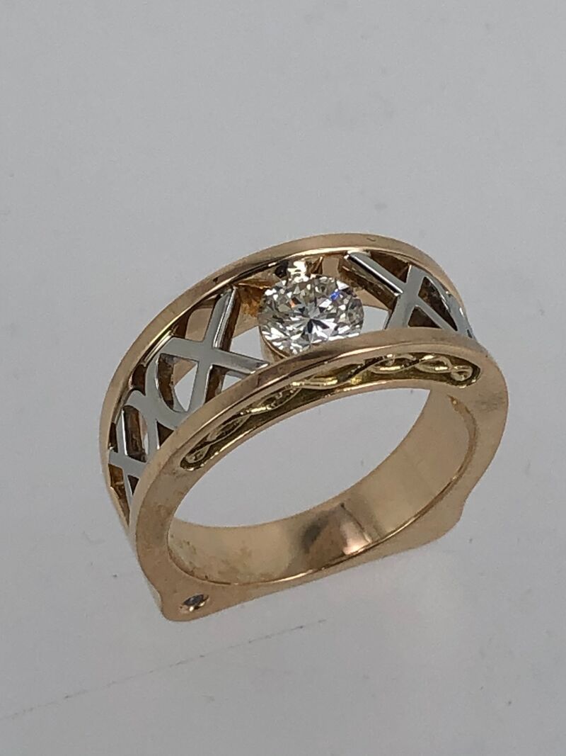 A crossover ring with a coloured stone and diamond shoulders
