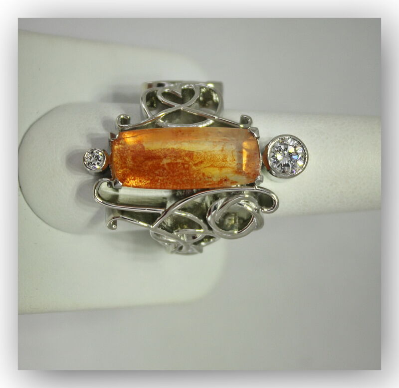 A custom ring with a hand-set centre stone and floral goldwork
